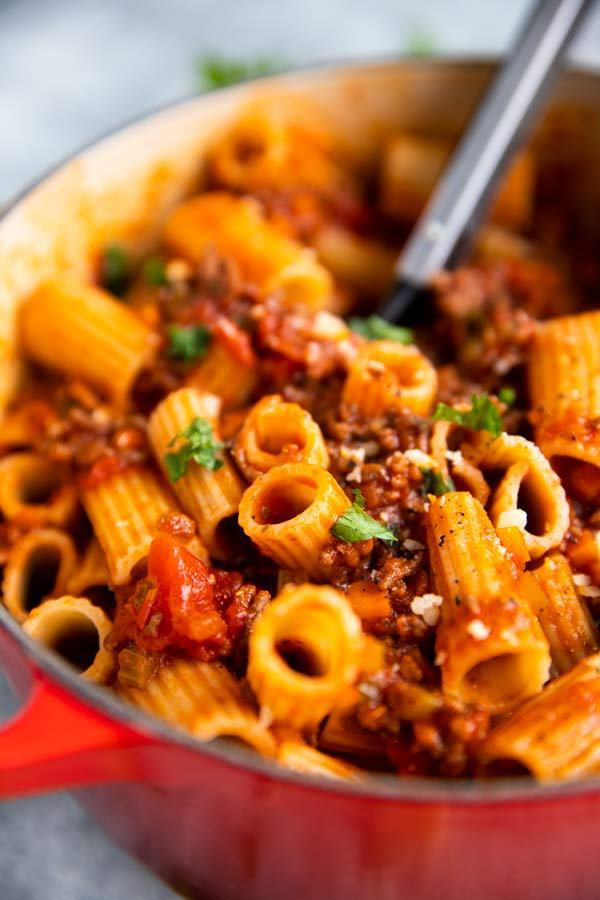 ein roter Gusseisentopf mit one pot pasta mit hackfleischsauce