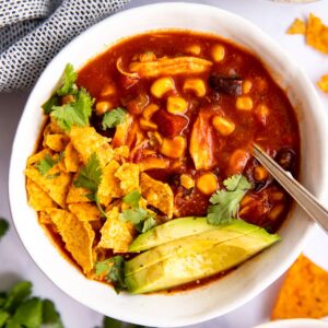 schale mit Mexikanischer Hühnersuppe, Tortilla Chips und Avocado