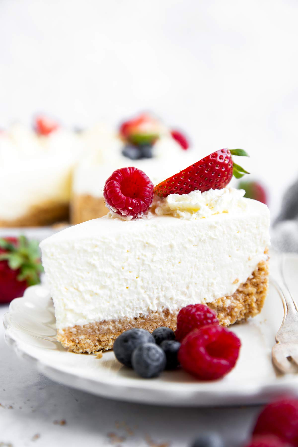 Stück Kühlschranktorte auf einem Teller mit Beeren