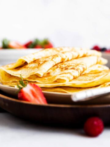 Stapel Pfannkuchen auf einer Platte mit Beeren