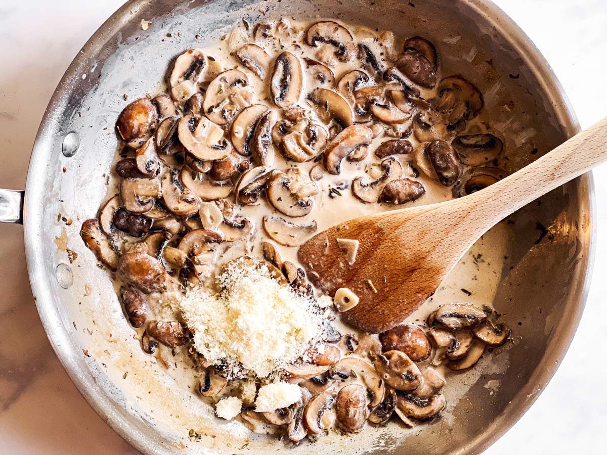 Pfanne mit Rahmchampignons und geriebenem Parmesan